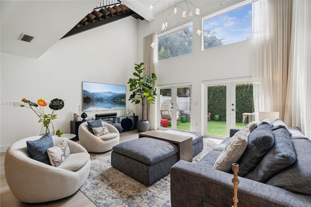 living room with french doors, hardwood / wood-style flooring, and high vaulted ceiling