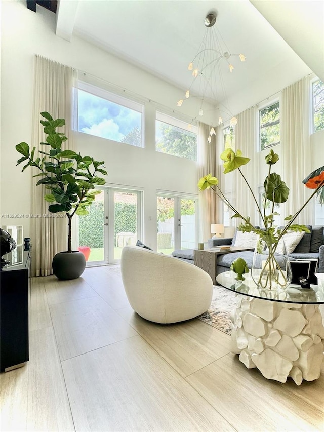 sunroom featuring french doors and a notable chandelier