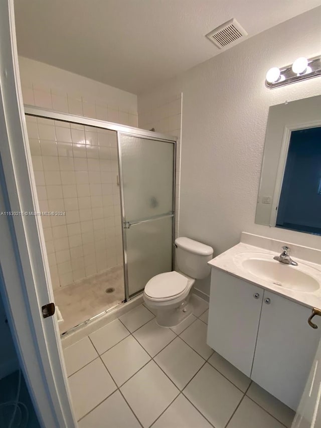 bathroom featuring walk in shower, tile patterned floors, vanity, and toilet