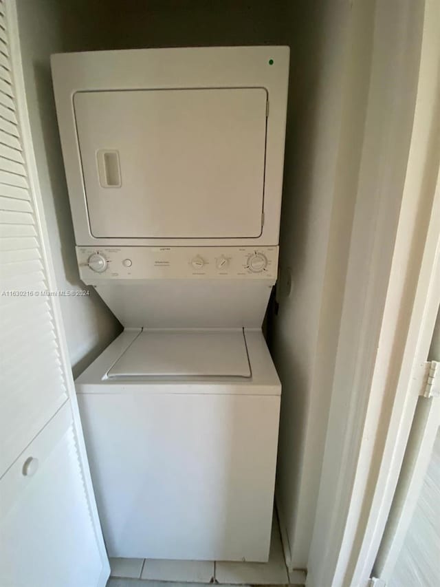 washroom featuring stacked washer / drying machine