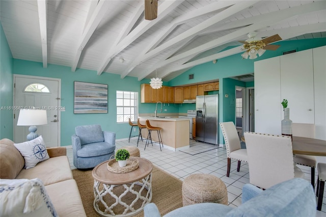 tiled living room featuring sink, vaulted ceiling with beams, and ceiling fan