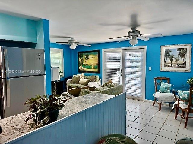 tiled living room with a healthy amount of sunlight and ceiling fan