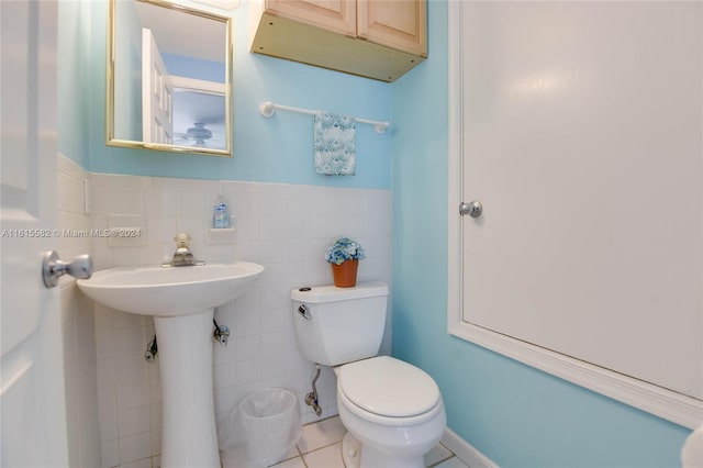 bathroom featuring tile walls, tile patterned flooring, and toilet