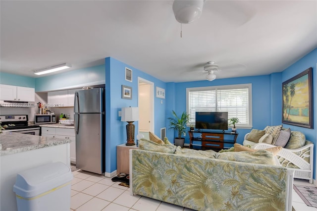 tiled living room featuring ceiling fan