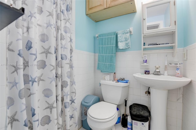 bathroom featuring curtained shower, tile walls, and toilet