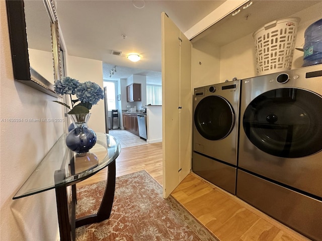 laundry area with independent washer and dryer, laundry area, light wood-type flooring, and visible vents