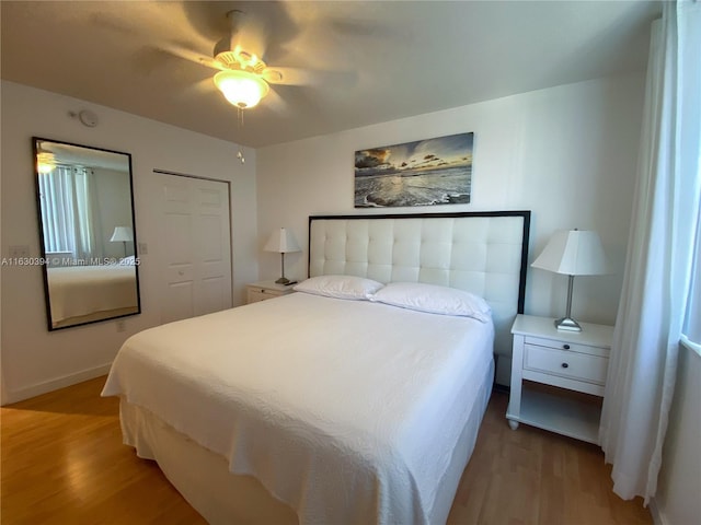 bedroom featuring a ceiling fan, baseboards, and wood finished floors