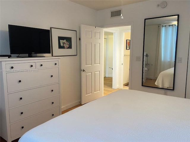 bedroom with light wood-type flooring, baseboards, and visible vents