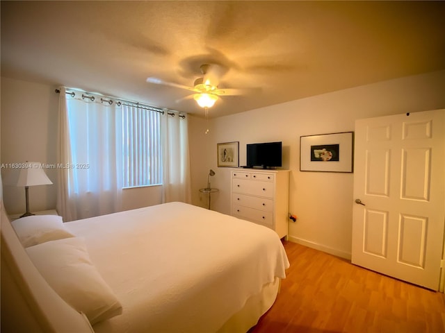 bedroom featuring light wood-type flooring, ceiling fan, and baseboards