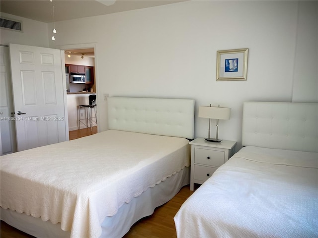 bedroom featuring visible vents and wood finished floors