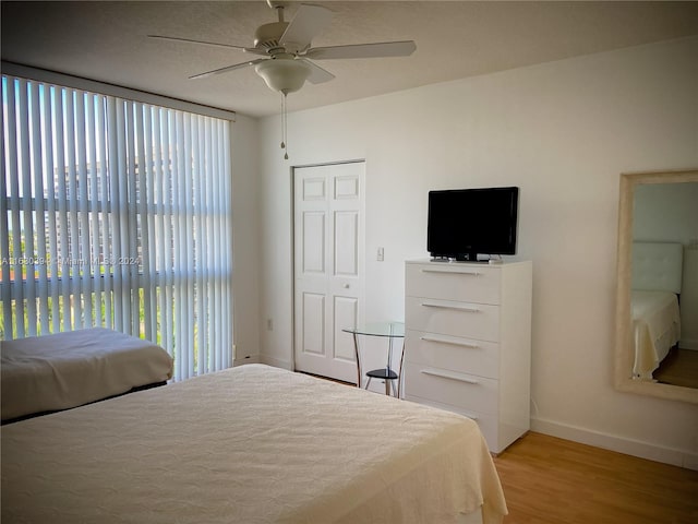 bedroom with ceiling fan, light hardwood / wood-style flooring, and a closet