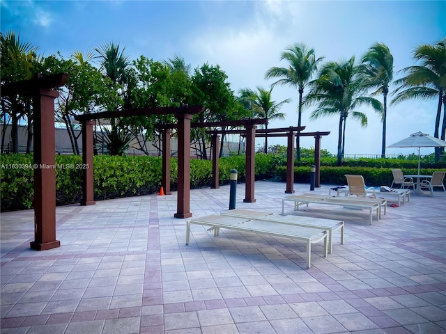 view of property's community featuring fence, a pergola, and a patio