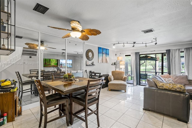 tiled dining room with a textured ceiling, ceiling fan, a healthy amount of sunlight, and crown molding