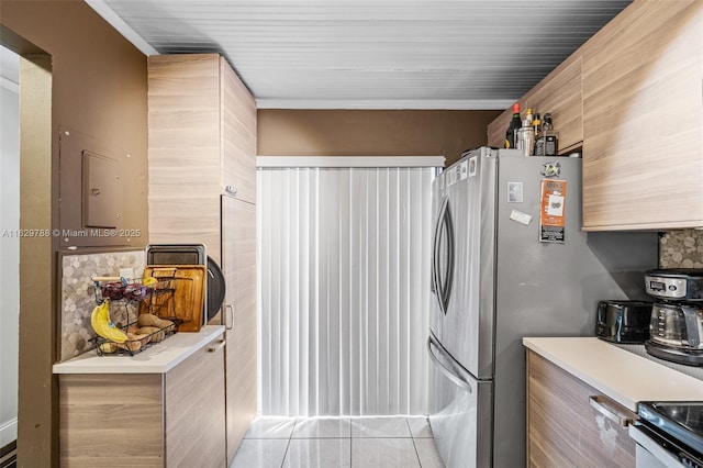 kitchen featuring stainless steel fridge, tasteful backsplash, and light tile patterned floors