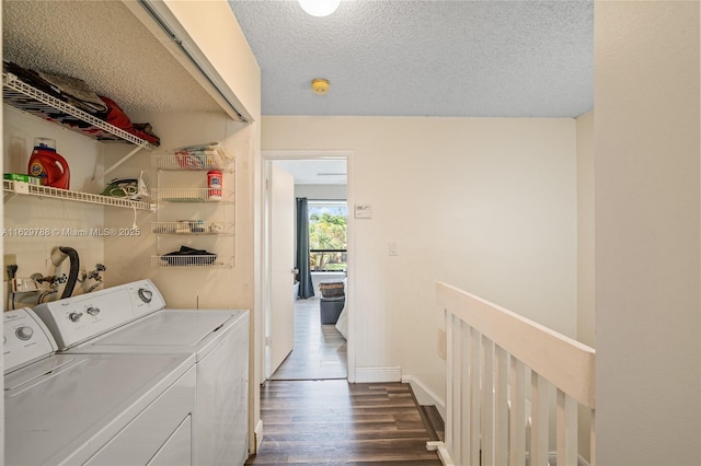 laundry area featuring a textured ceiling, washer and clothes dryer, and dark hardwood / wood-style floors