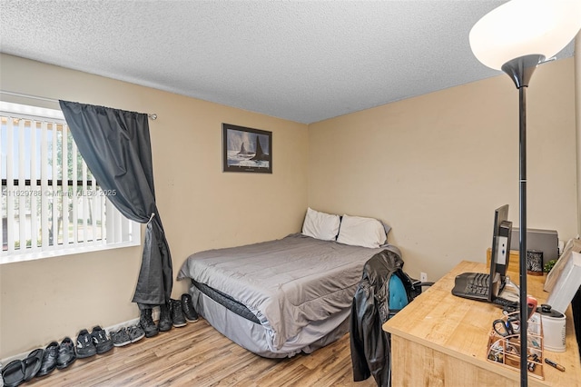 bedroom featuring a textured ceiling and wood-type flooring