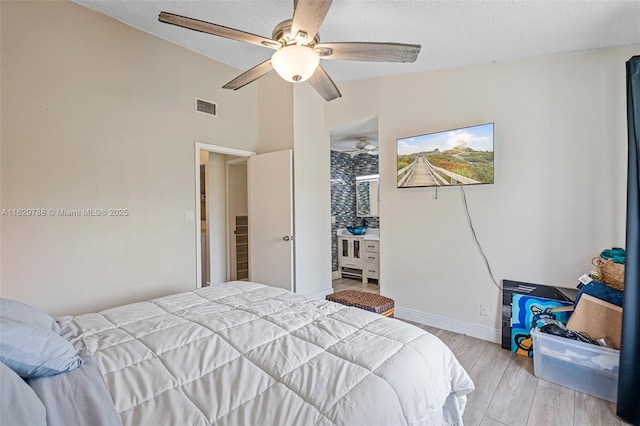 bedroom with ceiling fan, vaulted ceiling, and light hardwood / wood-style flooring