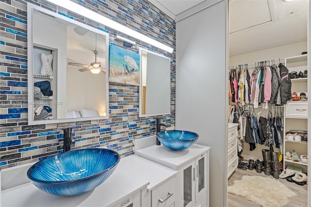 bathroom featuring vanity, decorative backsplash, and ceiling fan