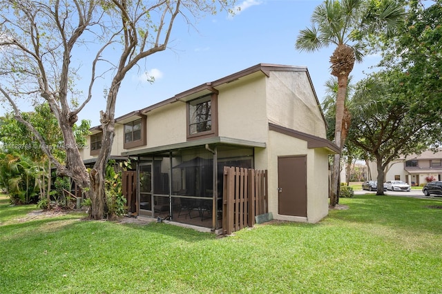 back of property featuring a yard and a sunroom