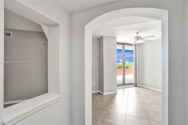 hallway with expansive windows and light tile patterned flooring