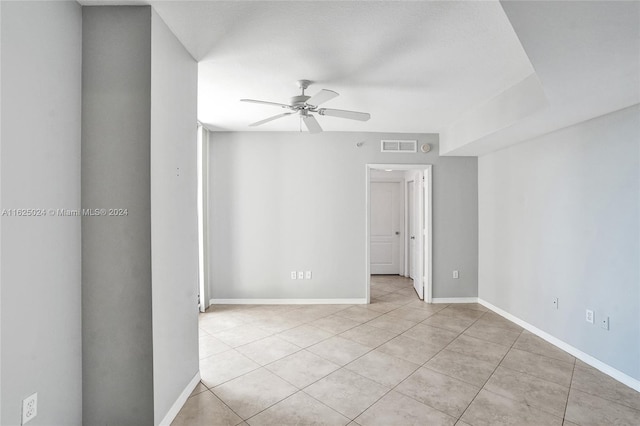 tiled empty room featuring ceiling fan