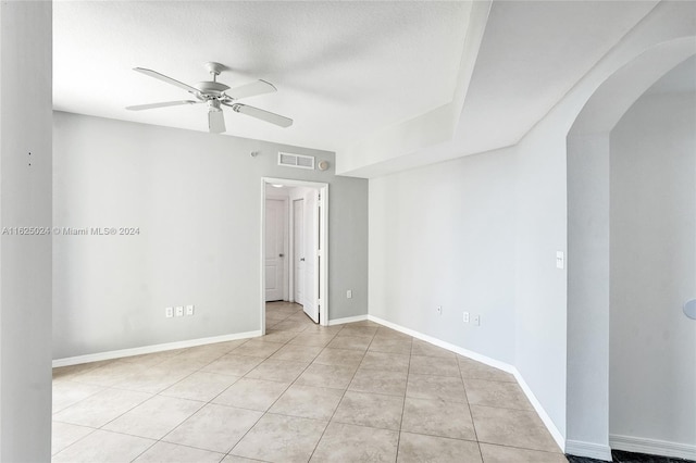 spare room featuring ceiling fan, a textured ceiling, and light tile patterned flooring