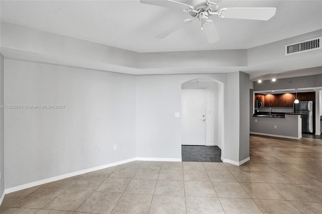 empty room featuring light tile patterned floors and ceiling fan