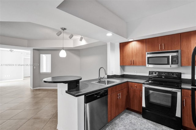 kitchen featuring kitchen peninsula, pendant lighting, appliances with stainless steel finishes, sink, and light tile patterned floors