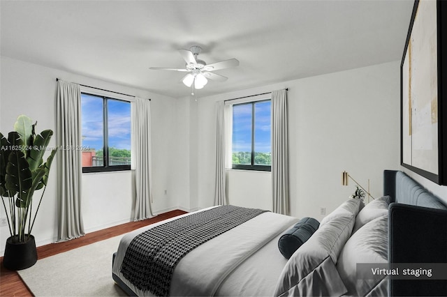 bedroom with ceiling fan, hardwood / wood-style floors, and multiple windows