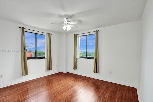 spare room featuring ceiling fan, plenty of natural light, and hardwood / wood-style floors