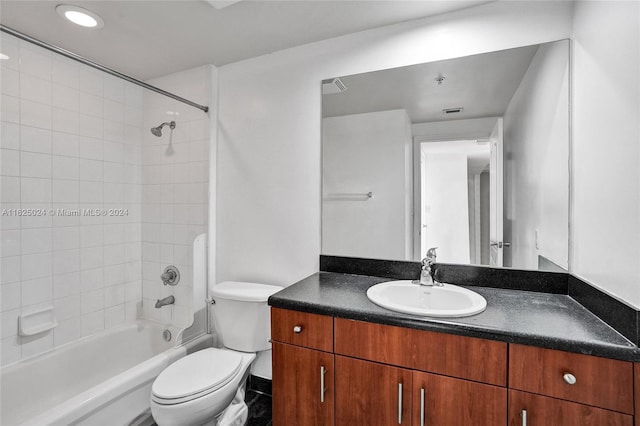 full bathroom featuring toilet, vanity, and tiled shower / bath