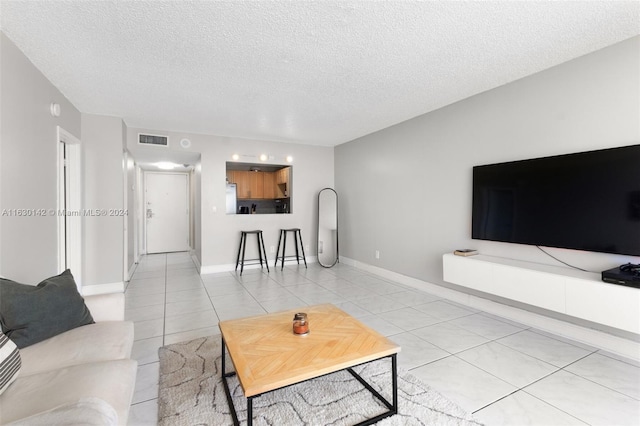 living room featuring light tile patterned floors and a textured ceiling