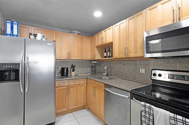 kitchen featuring sink, light tile patterned floors, light brown cabinets, and appliances with stainless steel finishes