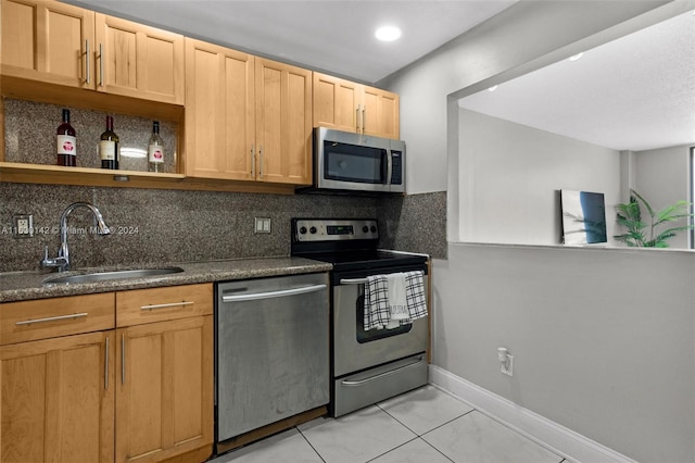 kitchen with light brown cabinets, sink, light tile patterned floors, tasteful backsplash, and stainless steel appliances