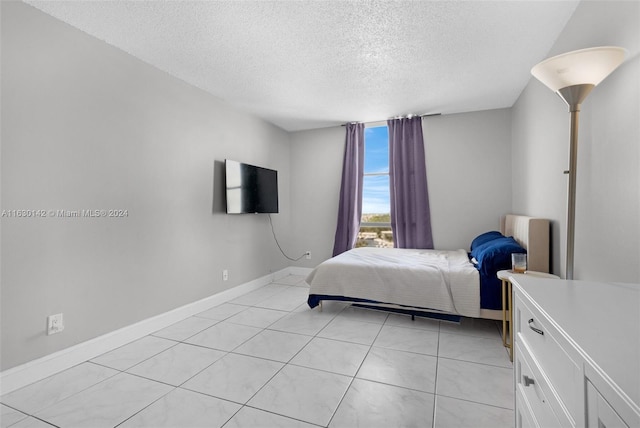 tiled bedroom featuring a textured ceiling