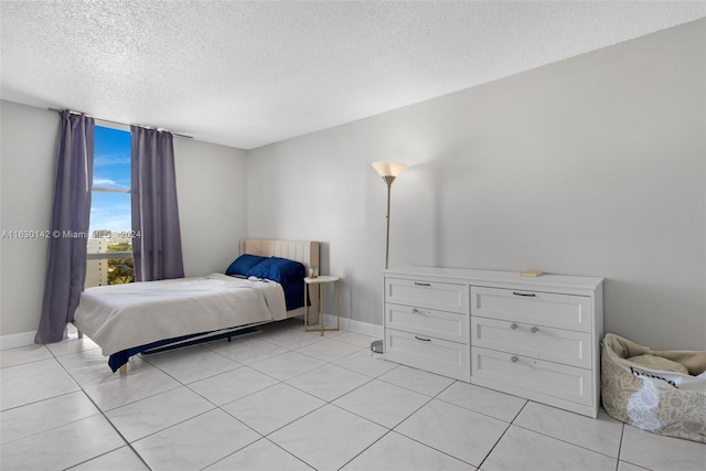 tiled bedroom featuring a textured ceiling