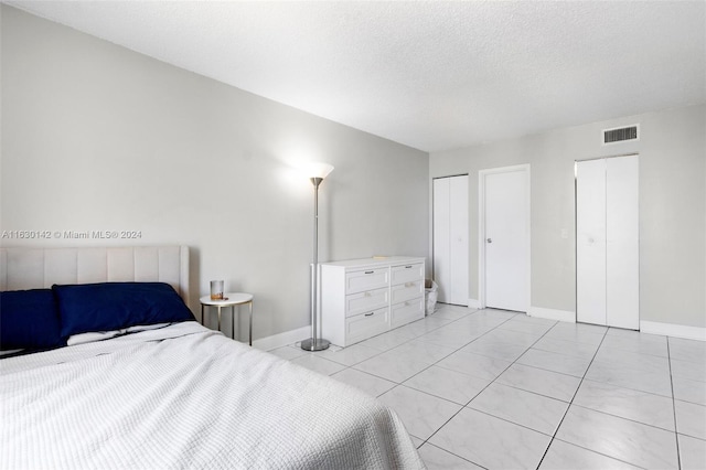 bedroom with light tile patterned floors and a textured ceiling