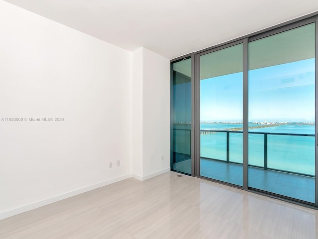 empty room with a water view and floor to ceiling windows