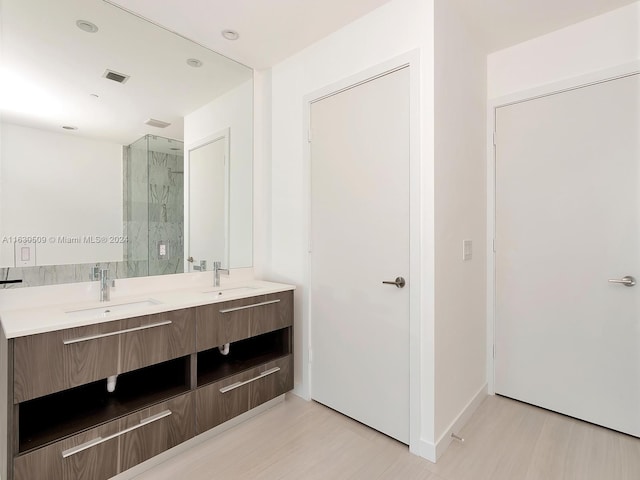 bathroom with a shower with door and vanity