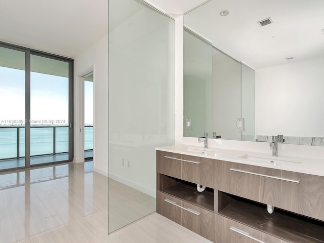 bathroom featuring a water view, tile patterned floors, floor to ceiling windows, and vanity