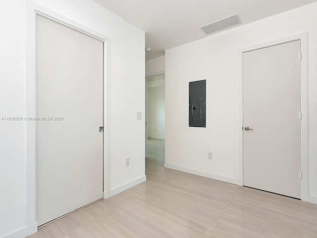 unfurnished bedroom with electric panel and light wood-type flooring