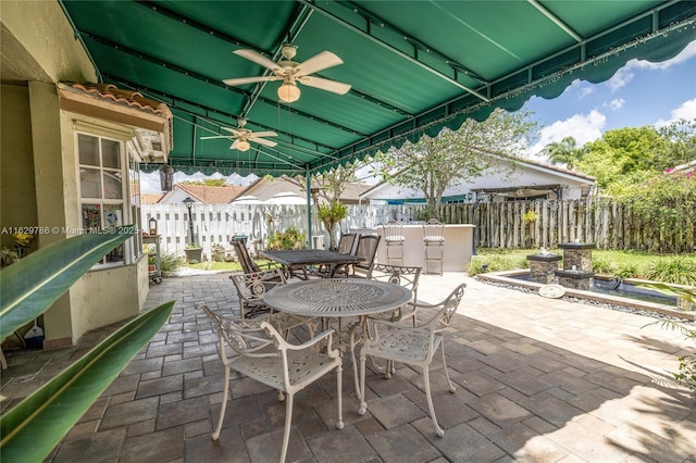 view of patio featuring ceiling fan and a bar