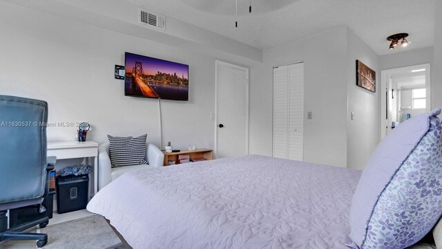 carpeted bedroom featuring a closet and a textured ceiling