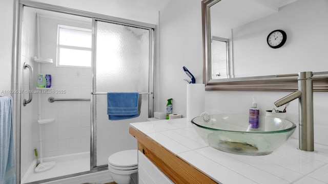 bathroom with vanity, a shower with door, and toilet