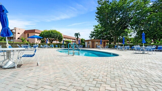 view of pool with an outbuilding and a patio