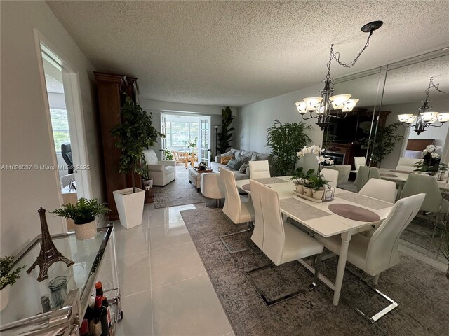 dining area with tile patterned floors, a chandelier, and a textured ceiling