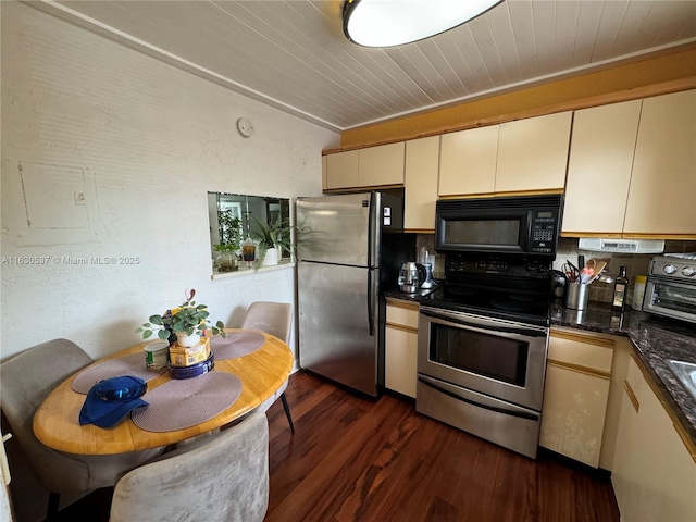 kitchen with vaulted ceiling, wooden ceiling, dark hardwood / wood-style flooring, stainless steel appliances, and cream cabinetry