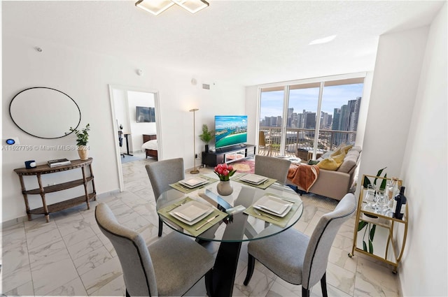 dining space featuring a textured ceiling and expansive windows