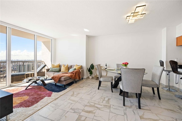 dining room featuring floor to ceiling windows, light tile patterned flooring, and a textured ceiling