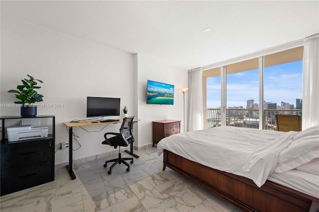 bedroom with a textured ceiling and a wall of windows